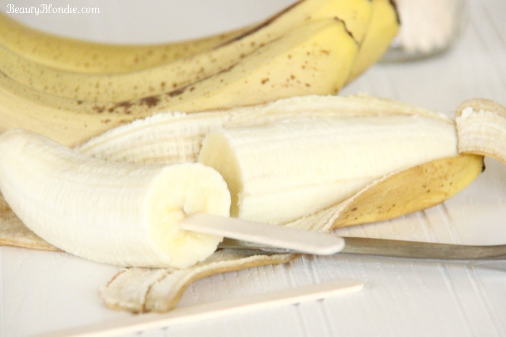 Put the popsicle stick inside the cut side of the banana